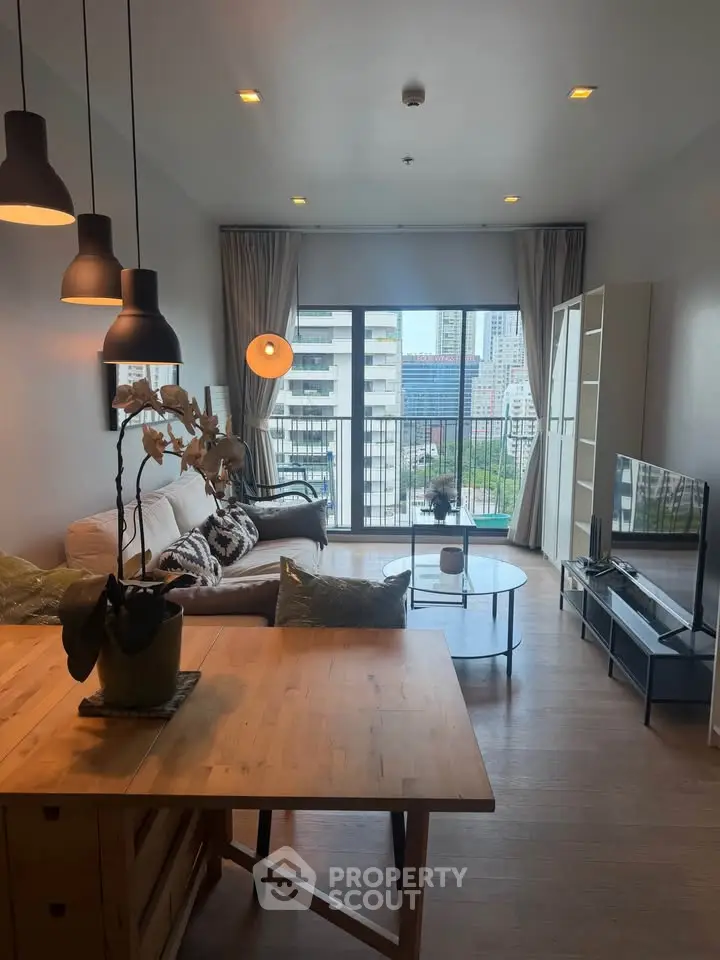 Modern living room with city view, stylish furniture, and natural light.