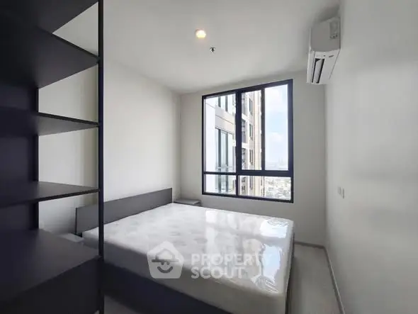 Modern minimalist bedroom with large window and city view