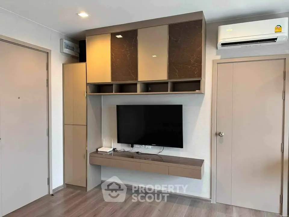 Modern living room with sleek TV unit and air conditioning in a stylish apartment.
