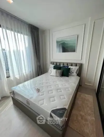Modern bedroom with stylish decor and large window offering natural light.