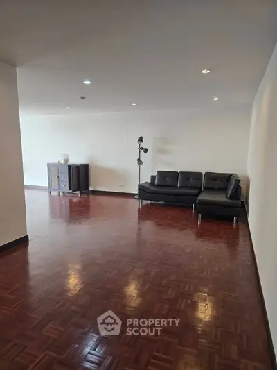 Spacious living room with elegant wooden flooring and modern furniture