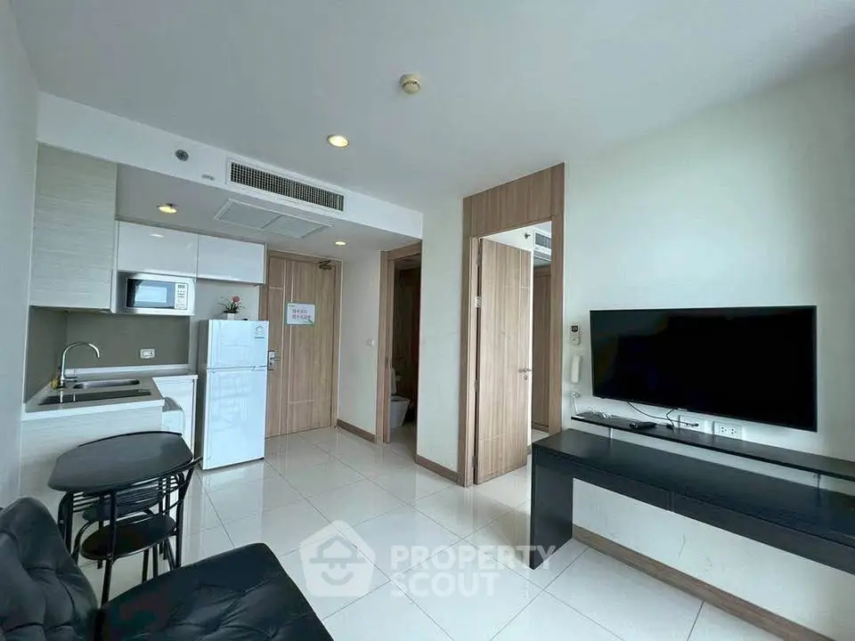 Modern living room with sleek kitchen and stylish furniture in a contemporary apartment.