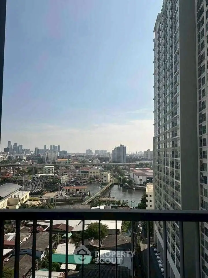 Stunning cityscape view from high-rise balcony overlooking urban skyline and river.