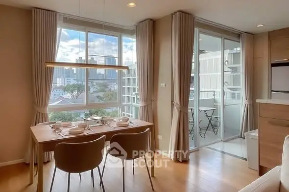 Modern dining area with large windows and balcony view in a stylish apartment.