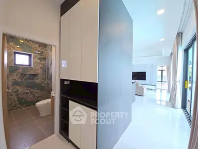 Modern open-plan living room with sleek kitchen and luxurious bathroom