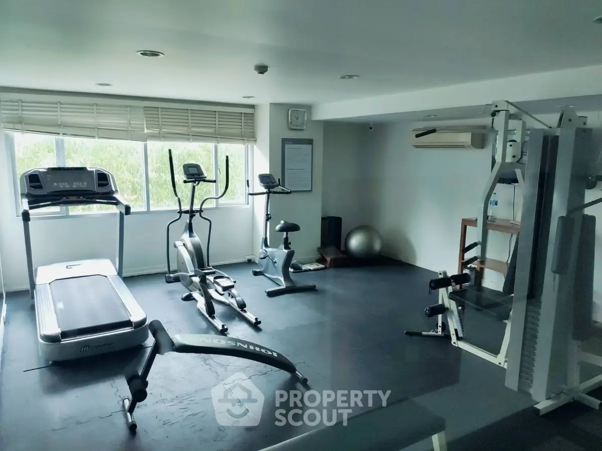 Modern gym with exercise equipment and natural light in a real estate property