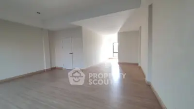 Spacious and well-lit empty living room with hardwood flooring and ample wall space, ideal for custom interior design.