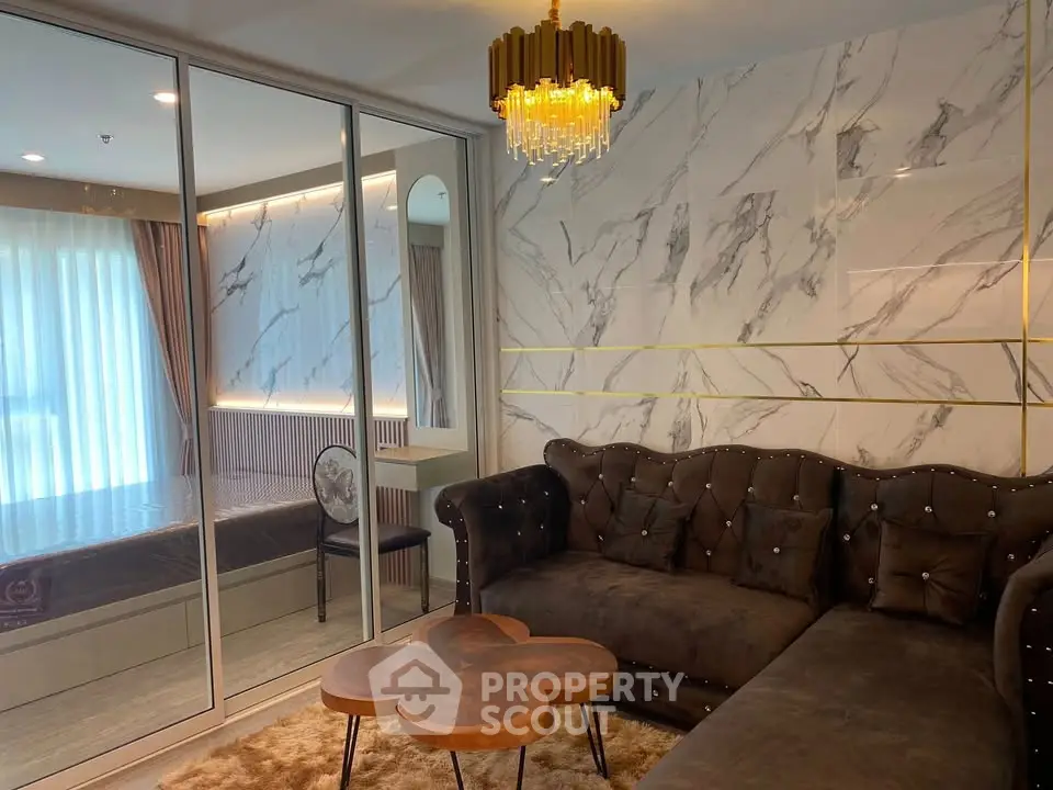 Luxurious living room with marble accent wall and elegant chandelier