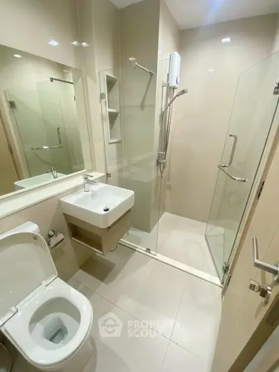 Modern bathroom with glass shower and sleek fixtures in a contemporary apartment.