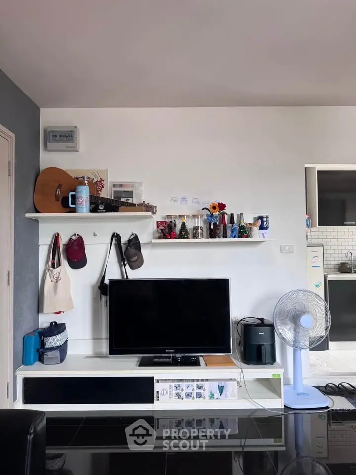 Modern living room with TV, shelves, and fan in stylish apartment