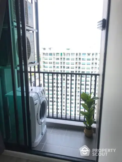 Modern balcony with washing machine and city view, perfect for urban living convenience.