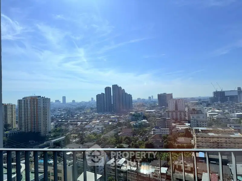 Stunning cityscape view from high-rise balcony with clear blue sky