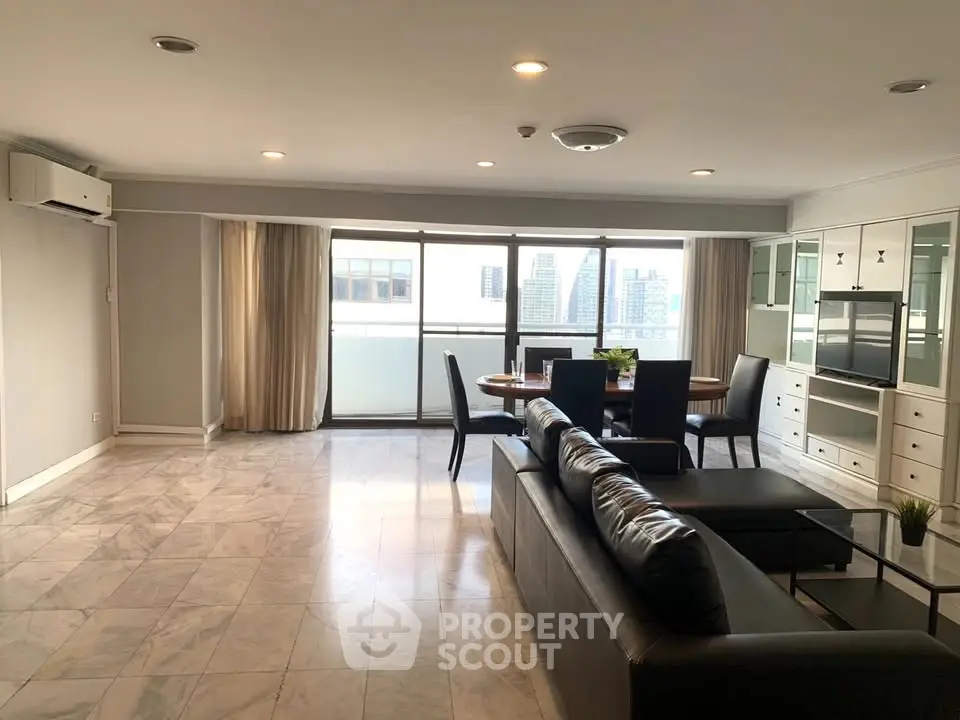 Spacious modern living room with city view, featuring sleek furniture and ample natural light.