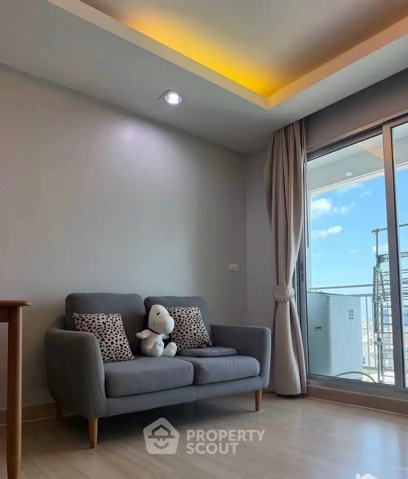 Cozy living room with modern sofa and balcony view, perfect for relaxation.