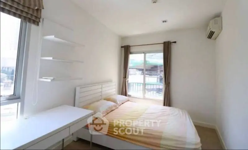 Bright and airy bedroom with large windows and modern decor, perfect for relaxation.