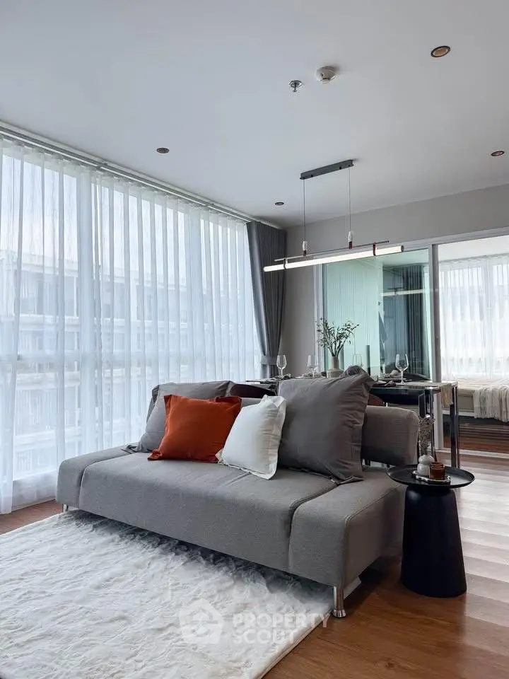Modern living room with stylish sofa and floor-to-ceiling windows in a chic apartment.