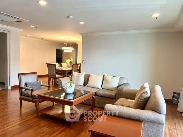 Spacious living room with elegant wooden flooring and cozy seating area in modern apartment.