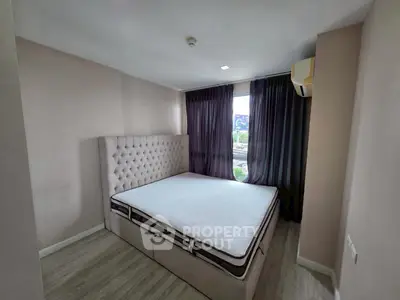 Spacious bedroom with elegant tufted headboard and large window view