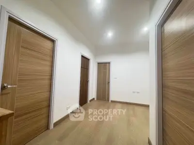Spacious hallway with wooden doors and modern lighting
