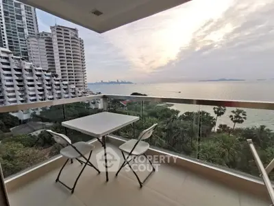 Stunning balcony view overlooking the ocean with modern high-rise buildings and lush greenery.