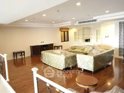 Spacious living room with elegant hardwood floors and modern furniture in a luxurious apartment.