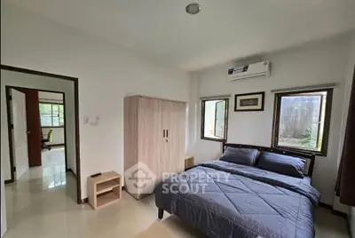 Cozy bedroom with modern decor and natural light, featuring a comfortable bed and air conditioning.