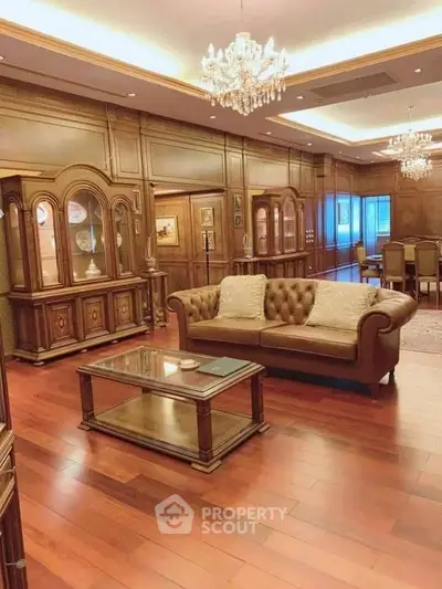 Luxurious living room with elegant wooden decor and chandeliers, perfect for sophisticated gatherings.