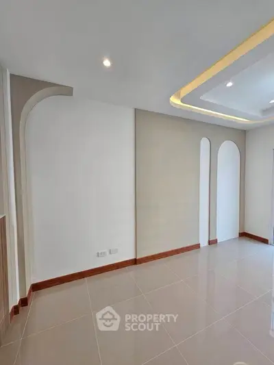 Modern minimalist interior with elegant ceiling design and glossy tiled flooring.
