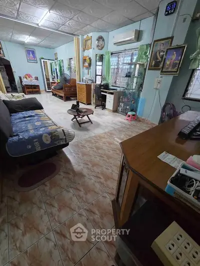 Spacious living room with tiled floor, cozy seating, and natural light.