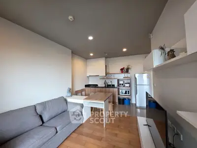 Modern open-layout kitchen and living room with sleek furniture and appliances.