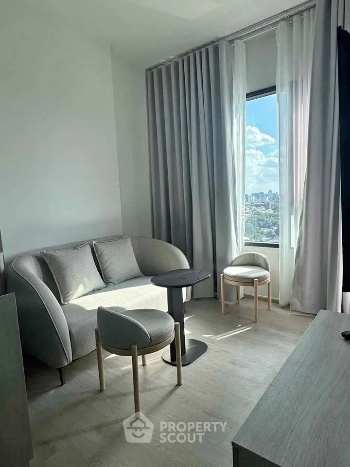 Modern living room with stylish furniture and panoramic city view.