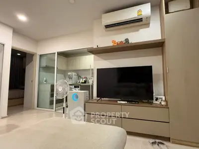 Modern living room with air conditioning and sleek TV setup in a cozy apartment.