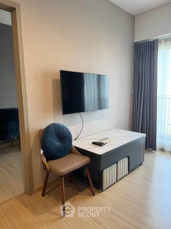 Modern living room with wall-mounted TV and stylish furniture in a bright apartment.