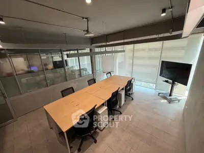 Modern office space with conference table and large windows offering natural light