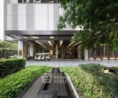 Modern building entrance with lush greenery and sleek design