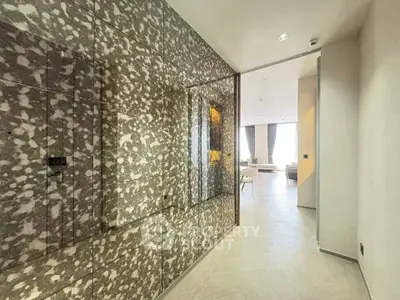 Luxurious hallway with modern design leading to a spacious living room with large windows.