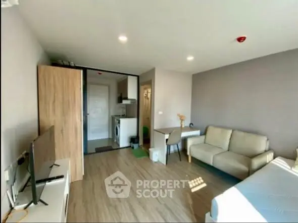 Modern studio apartment with cozy living area and washing machine