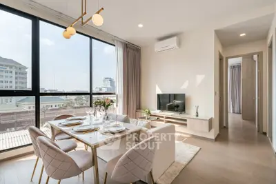 Modern living room with dining area, large windows, and stylish decor in a high-rise apartment.