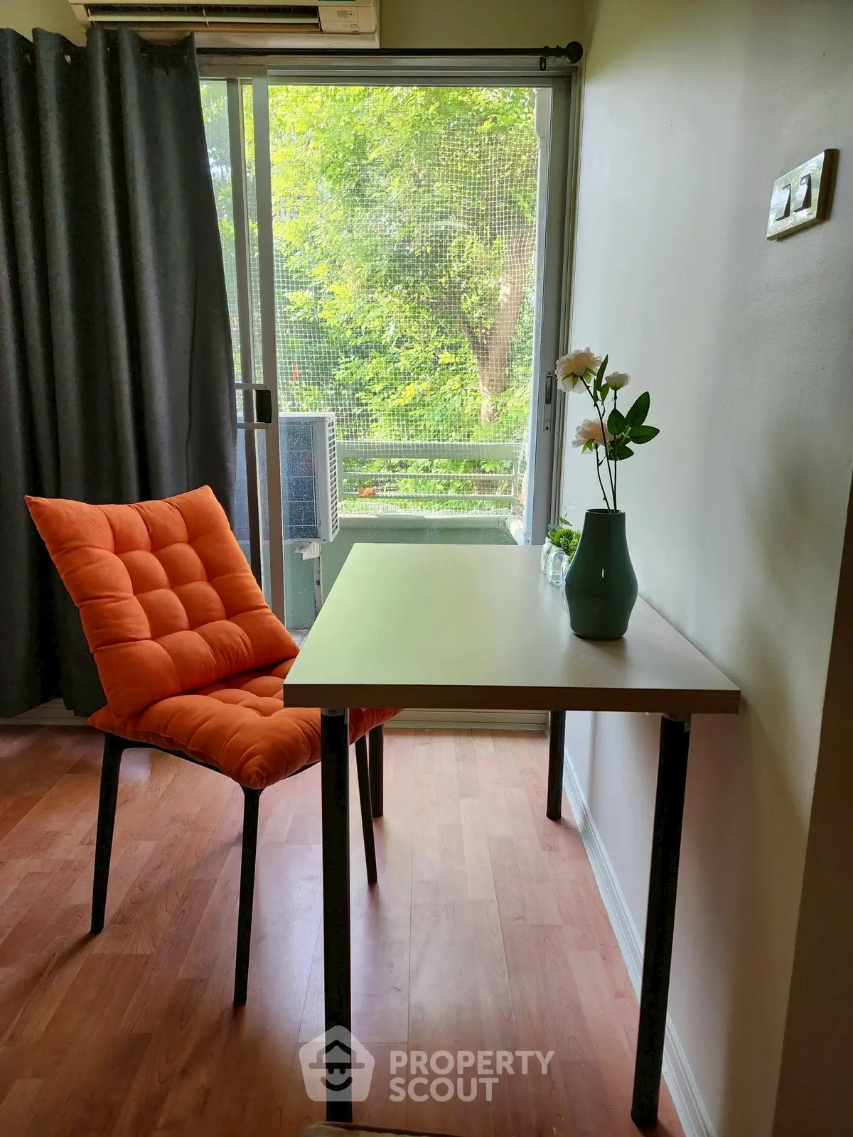 Cozy study nook with vibrant orange chair and window view, perfect for productivity and inspiration.