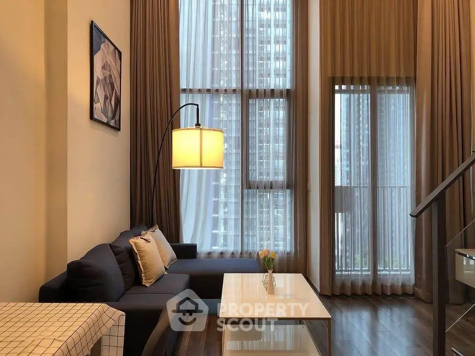 Luxurious high-ceiling living room with modern decor and large windows offering stunning city views.