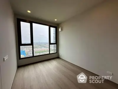 Spacious empty room with large window offering stunning city view