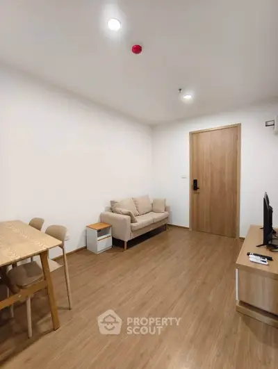 Modern living room with wooden flooring, cozy sofa, and dining area in a stylish apartment.
