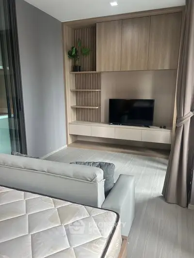 Modern living room with sleek built-in TV unit and cozy sofa, perfect for relaxation.