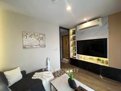 Modern living room with sleek design, featuring a wall-mounted TV, air conditioning, and stylish decor.