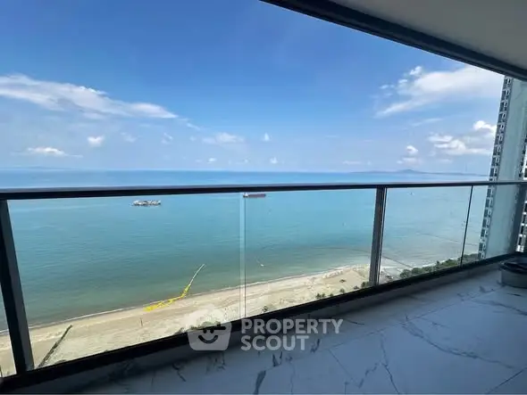 Stunning ocean view from a high-rise balcony with clear blue skies and serene beach.
