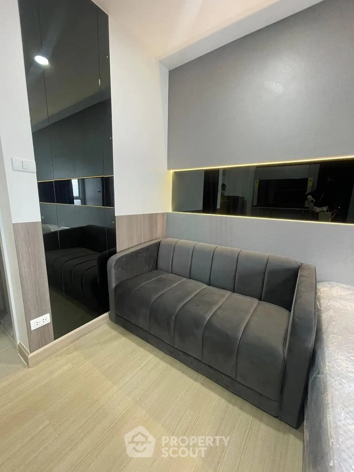 Modern living room with sleek black sofa and mirrored wall accents