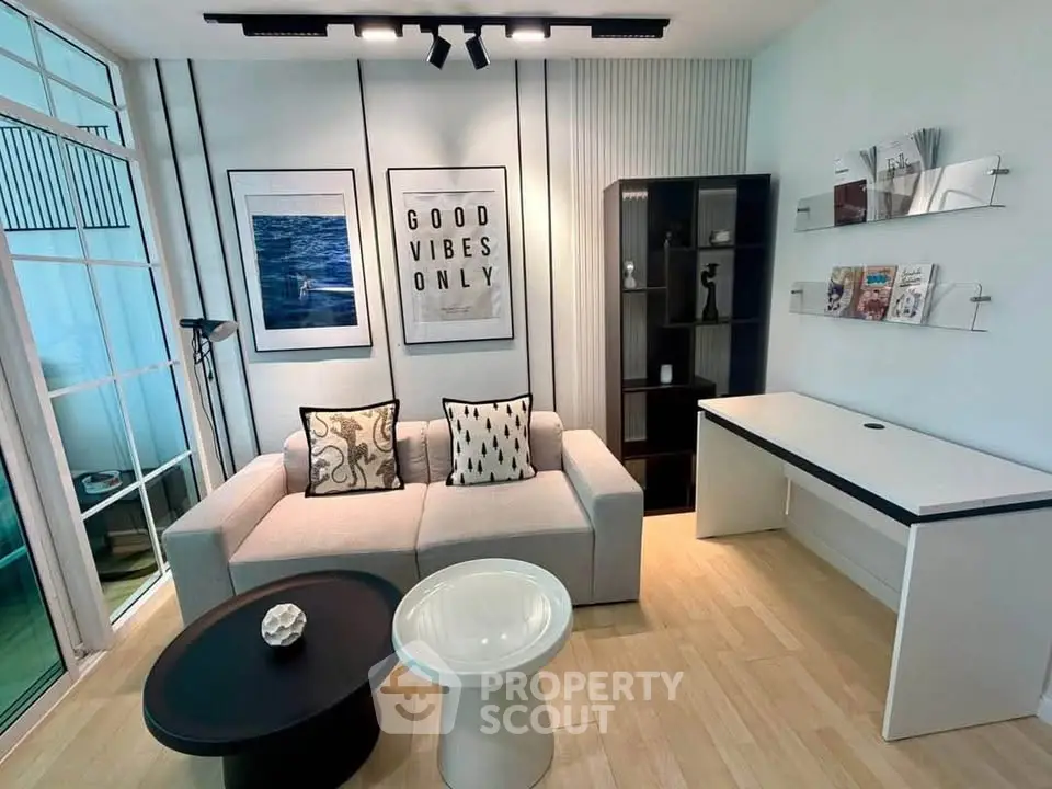 Modern living room with stylish decor and natural light, featuring a cozy sofa and chic coffee tables.