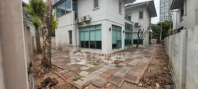 Spacious modern house with paved backyard and air conditioning units, ideal for family living.