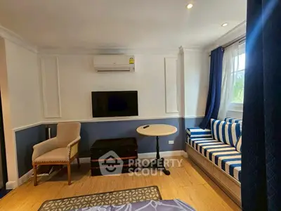 Charming living room with stylish seating and wall-mounted TV, perfect for relaxation and entertainment.