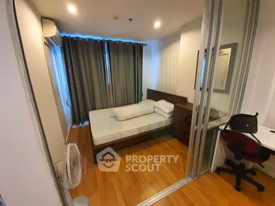 Cozy bedroom with wooden flooring, sliding glass doors, and modern furnishings in a stylish apartment.